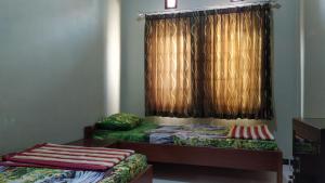 um quarto com duas camas e uma janela em Ijen Bondowoso Home Stay em Bondowoso