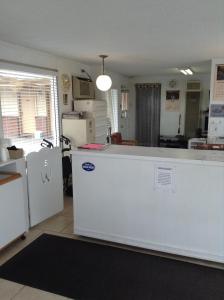 a kitchen with a white counter and a refrigerator at Ski's Western Motel in Great Falls
