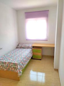 a bedroom with a bed and a desk and a window at Apartamento Florencia in Murcia