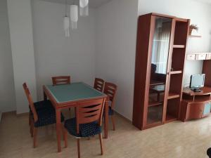 a dining room with a table and chairs and a cabinet at Apartamento Florencia in Murcia