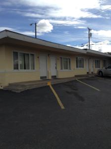 ein Gebäude mit einem Auto auf einem Parkplatz in der Unterkunft Plaza Inn in Great Falls