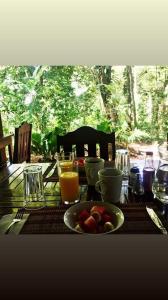 a table with a bowl of fruit and glasses of orange juice at Mombacho Lodge in Granada