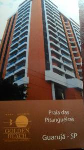 a tall building with a sign in front of it at Residencial flat Golden beach.. in Guarujá