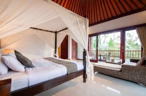 Postel nebo postele na pokoji v ubytování Flamboyant Villa Ubud
