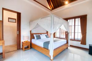 Postel nebo postele na pokoji v ubytování Flamboyant Villa Ubud