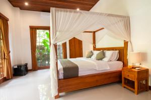 Postel nebo postele na pokoji v ubytování Flamboyant Villa Ubud