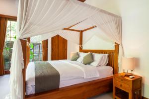 Postel nebo postele na pokoji v ubytování Flamboyant Villa Ubud