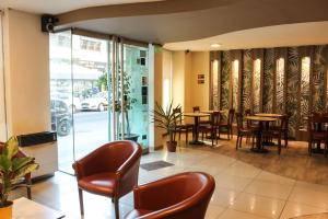 a restaurant with wooden tables and chairs and windows at Savannah Cordoba Hotel in Córdoba