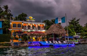 a hotel on the water with chairs in front of it at Hostal Casa de Grethel in Flores