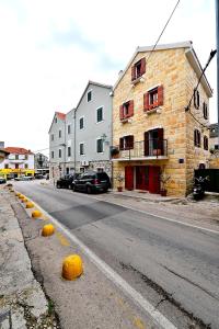 een lege straat met gebouwen en auto's op de weg bij Sunny Bobica Apartments in Vodice