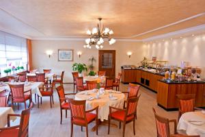 a dining room with tables and chairs and a restaurant at Hotel Rosenhof in Kerpen