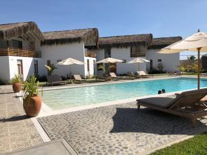 a resort with a swimming pool with chairs and umbrellas at PARADISE EN VICHAYITO in Vichayito