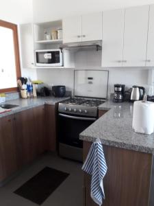 a kitchen with white cabinets and a stove top oven at PARADISE EN VICHAYITO in Vichayito