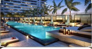 Una gran piscina con sillas y un edificio. en Hide House, en Hollywood