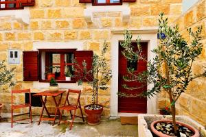 a table and chairs in front of a building with a red door at Sunny Bobica Apartments in Vodice