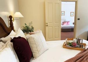 a bed with pillows and a tray of food on it at Mountain Heritage Hotel in Katoomba
