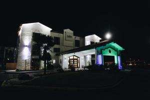 All Seasons Inn & Suites في ممفيس: مبنى أبيض مع أضواء زرقاء عليه في الليل
