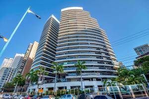 a tall building with cars parked in front of it at Apartamento de Luxo Landscape Beira Mar Platinum in Fortaleza