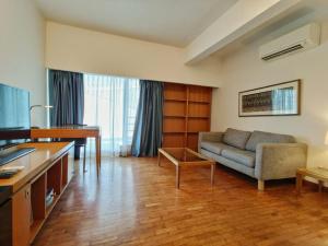 ein Wohnzimmer mit einem Sofa und einem Tisch in der Unterkunft Orchard Point Serviced Apartments in Singapur