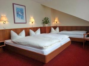 two beds in a hotel room with white pillows at Hotel Rosenhof in Kerpen
