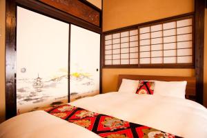 Un dormitorio con una cama y dos ventanas. en Yamagata Kyomachi Hatago Nishijin, en Kioto 54 fotos más