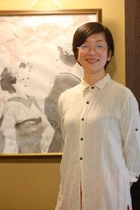 Una donna con gli occhiali in piedi davanti a un quadro di Yamagata Kyomachi Hatago Nishijin a Kyoto