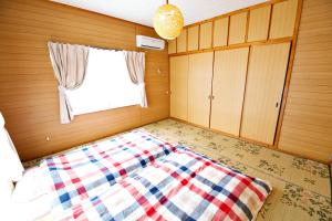 a bedroom with a bed and a window at Bi ONE House 2F in Yomitan