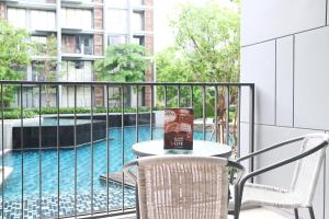 a table and chairs on a balcony with a pool at The Valley Moutain Khaoyai in Phayayen