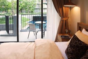 Pokój z łóżkiem i balkonem ze stołem w obiekcie The Valley Moutain Khaoyai w mieście Phayayen