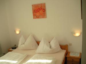 1 Schlafzimmer mit 2 Betten und weißen Kissen in der Unterkunft Neukumhof in Westendorf