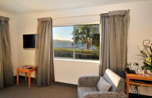 uma sala de estar com uma janela com vista para a água em Wai Ora Lakeside Spa Resort em Rotorua