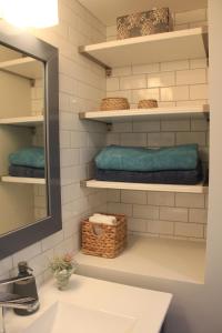 a bathroom with a sink and a mirror and towels at HiddenGem-private modern suite on trendy Main St in Vancouver