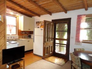 a kitchen with a white refrigerator and a table at Snowy Mountain Holidays in Towong