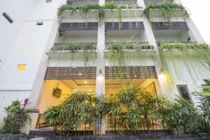 un edificio con plantas a su lado en RedDoorz at Benesari 2 Legian, en Kuta