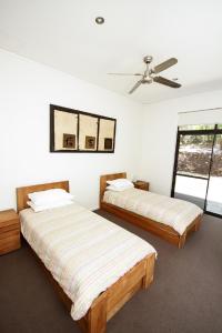 a bedroom with two beds and a ceiling fan at Shady Glen in Prevelly