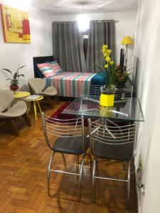 a glass table and chairs in a room with a couch at Apartamento Paim in São Paulo
