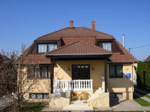 a yellow house with a tiled roof at Apartman Szanyi in Bük