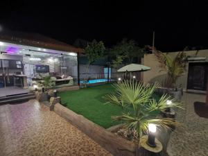 a backyard at night with a lawn and plants at Red Sea Resort (Families Only) in Rayyis