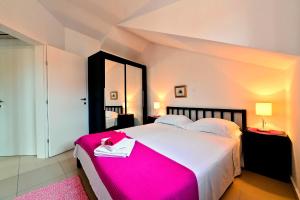a bedroom with a large bed with a pink blanket at Sunny Bobica Apartments in Vodice