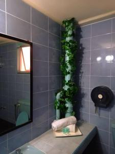 a bathroom with a green plant on the wall at City Inn in Kuching