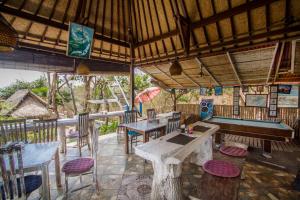 a restaurant with tables and chairs on a patio at The Dafish Ceningan in Nusa Lembongan