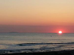 a sunset over the ocean with the sun in the horizon at Piccolo Hotel in Rosignano Solvay