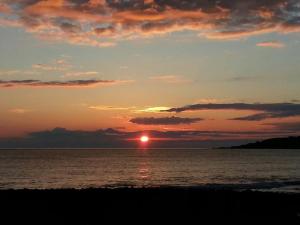 a sunset over the ocean with the sun in the sky at Piccolo Hotel in Rosignano Solvay