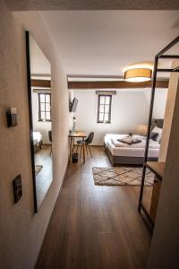 a bedroom with a bed and a desk and a mirror at STEINHAUS 1718 in Büdingen