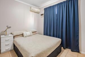 卡拉萨AAOK卡拉萨大篷车公园汽车旅馆的一间卧室配有床和蓝色窗帘