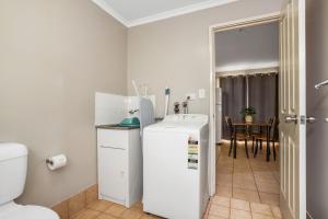 a kitchen with a white refrigerator and a table at AAOK Karratha Caravan Park in Karratha