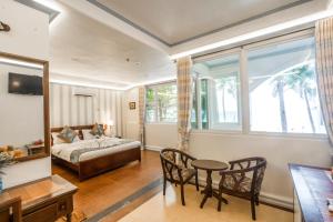 una camera con letto, tavolo e sedie di Royal Park Resort Boracay a Boracay
