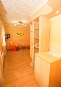 - un salon avec des murs orange et du parquet dans l'établissement Zhemchuzhina Kavkaza Hotel, à Jeleznovodsk