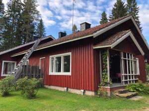 a red house with a red roof at Taikaloora-lomahuoneisto Oulujärvi in Vaala
