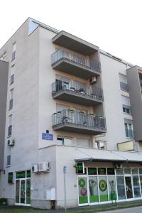 a white building with a balcony on top of it at Apartman Klara in Karlovac
